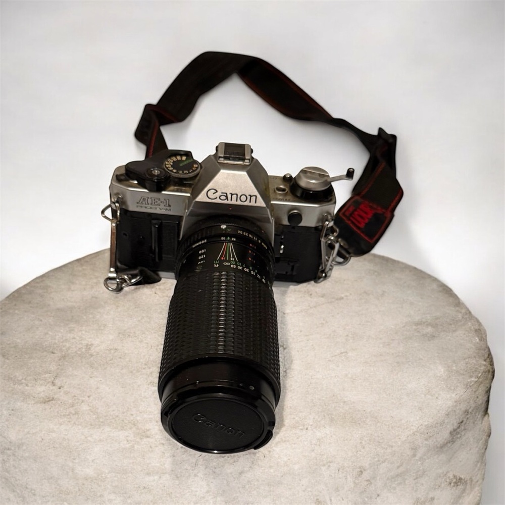 Canon silver and black SLR camera with black telephoto lens